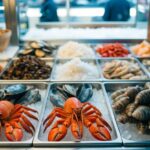 Uma vitrine de mercado de frutos do mar com uma variedade de crustáceos e moluscos comestíveis sobre gelo