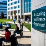 Um campus universitário movimentado com estudantes estudando e uma placa dizendo "Departamento de Contabilidade e Finanças" em um prédio moderno.